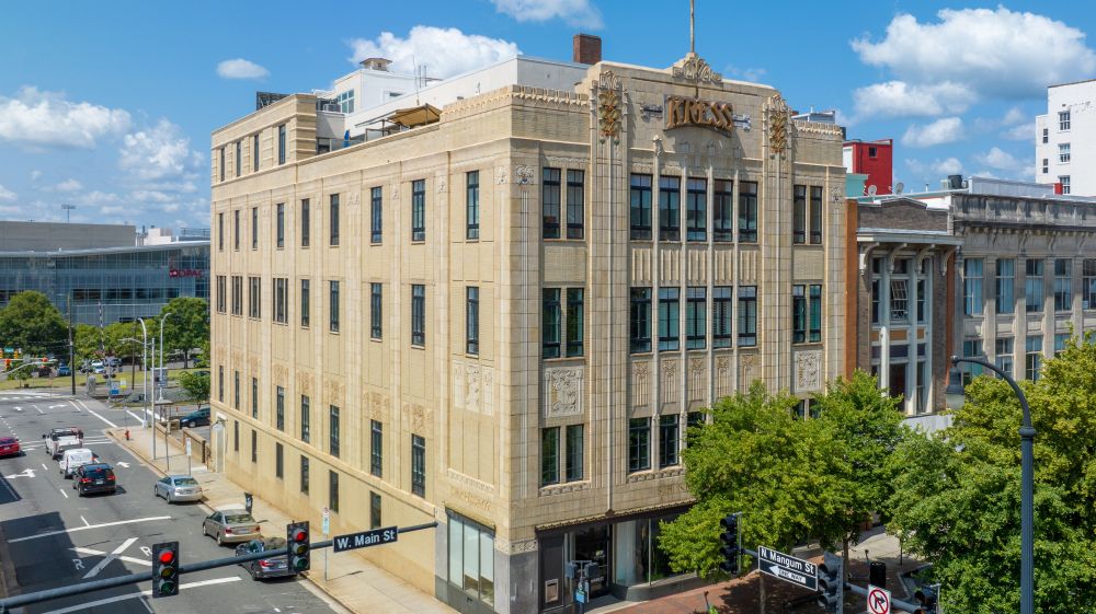 The gray Kress Building sits on the corner of a busy street in Durham, NC.